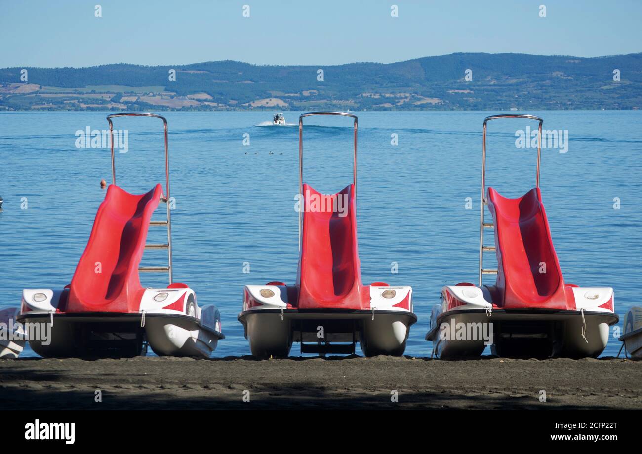 three pedal boats on the shore of bolsena lake, italy Stock Photo
