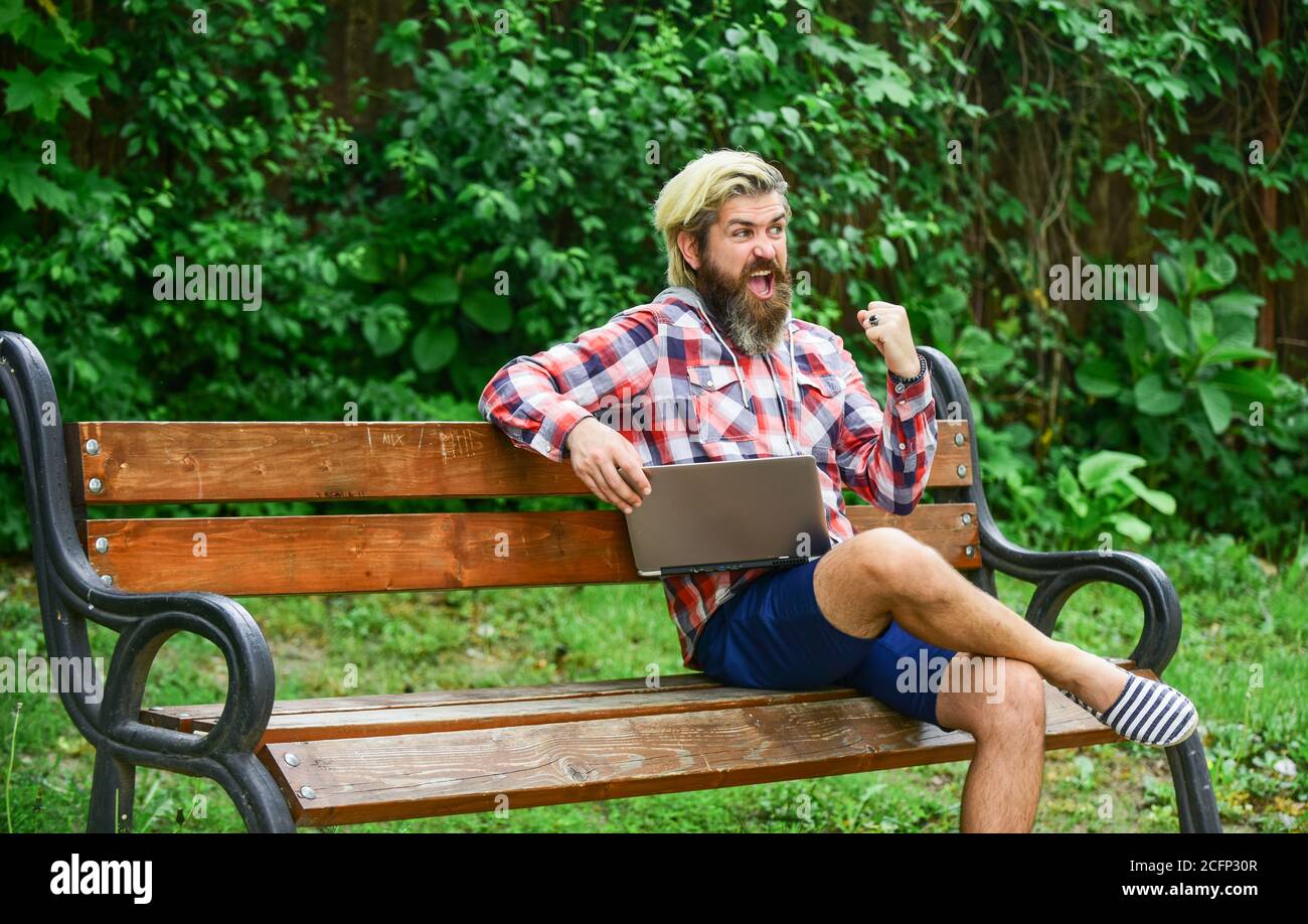 Fresh air. Mobile internet. Modern laptop. Remote job. Online shopping. Agile business. Bearded guy sit bench park nature background. Work and relax. Working online. Hipster inspired work in park. Stock Photo