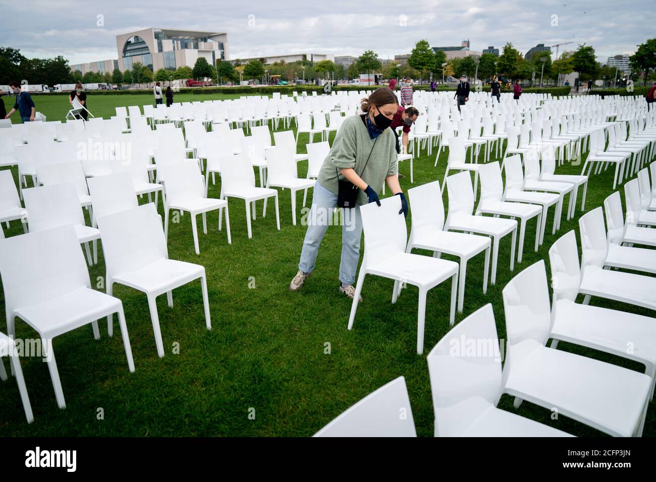 Berlin, Germany. 07th Sep, 2020. Helpers set up chairs on the Platz der Republik in front of the Reichstag building. As part of the nationwide anti-racist action days of 'We'll Come United', some 13,000 chairs will be placed here in front of the Bundestag later this afternoon. The chairs symbolise the people who currently live in Moria, as well as the square and the receptiveness of the cities, states and civil society. Organised jointly by Seebrücke, Sea-Watch, #LeaveNoOneBehind and Campact. Credit: Kay Nietfeld/dpa/Alamy Live News Stock Photo