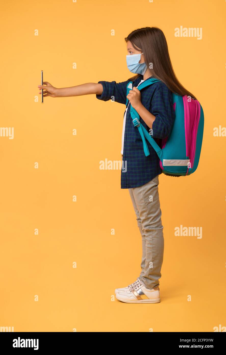 Schoolgirl showing cell phone with outstretched hand Stock Photo