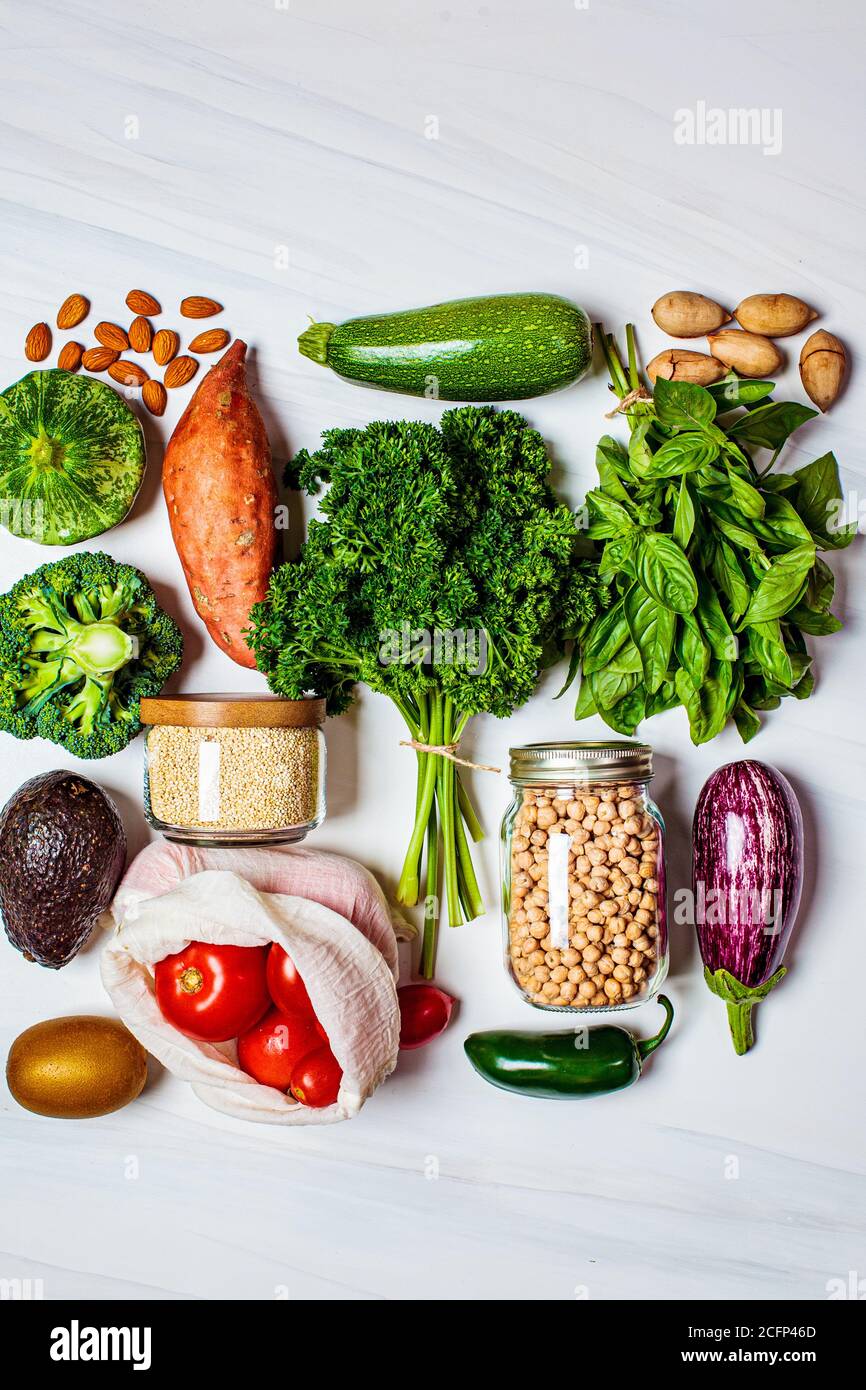 Healthy food flat lay. Fresh vegetables, fruits, nuts, quinoa, chickpeas on a white background. Zero waste, vegan food, eco friendly concept. Stock Photo