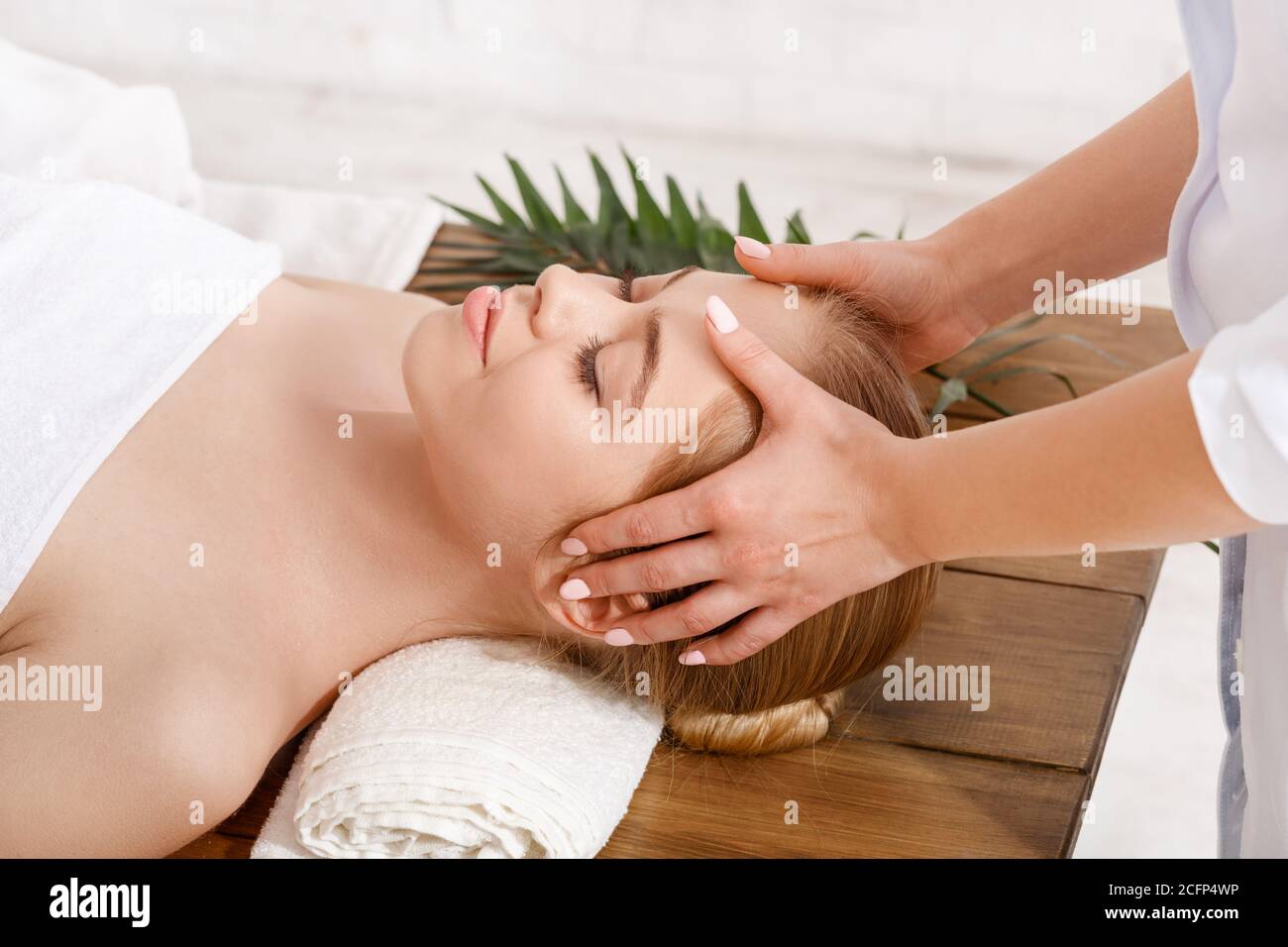 Beauty treatments. Professional doing facial massage for girl on table Stock Photo