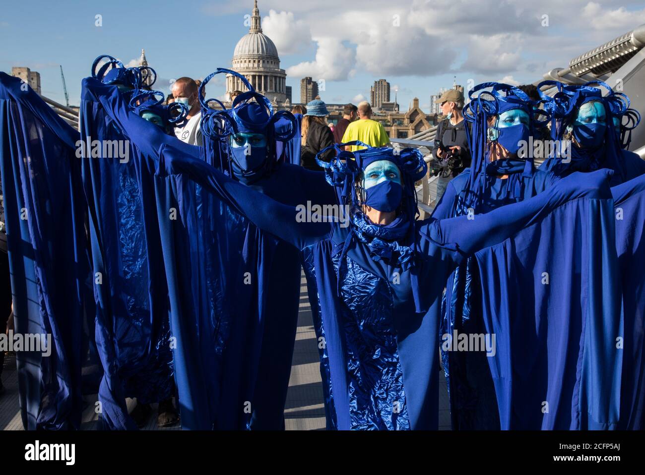 London, UK. 6th September, 2020. The blue rebels cross the Millennium Bridge with fellow climate activists from the Ocean Rebellion and Extinction Rebellion during a colourful Marine Extinction March. The activists, who are attending a series of September Rebellion protests around the UK, are demanding environmental protections for the oceans and calling for an end to global governmental inaction to save the seas. Credit: Mark Kerrison/Alamy Live News Stock Photo