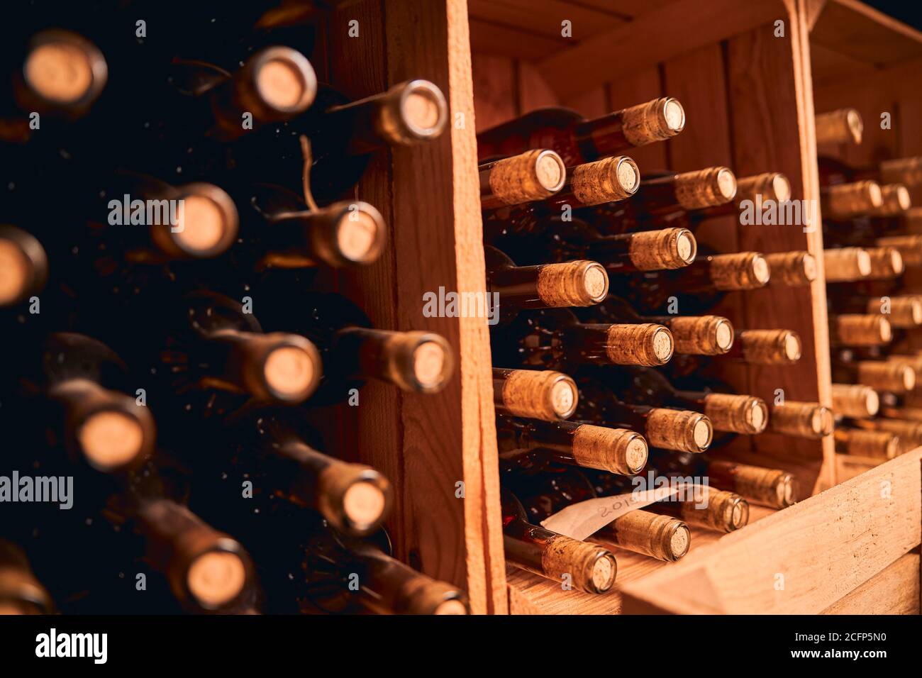 Bottles of wine stored in wooden racks Stock Photo Alamy