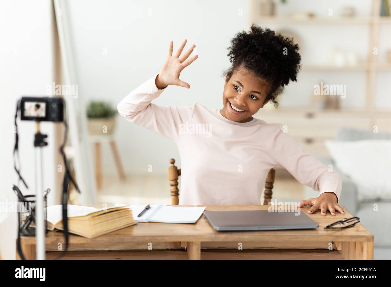 African American Girl Making Video Waving Hand At Home Stock Photo - Alamy