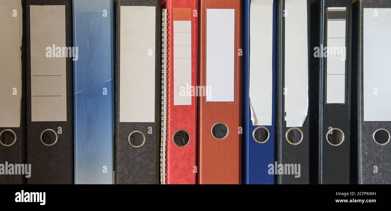 Colored folders for office files and paper on a shelf. Background image Stock Photo