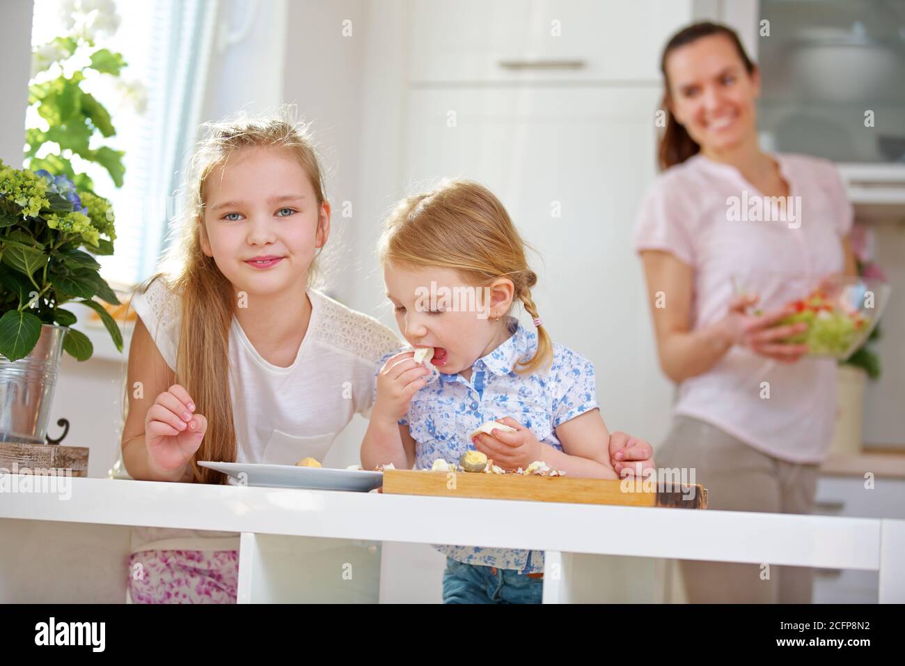 Two children in a family eat boiled eggs for breakfast Stock Photo Alamy
