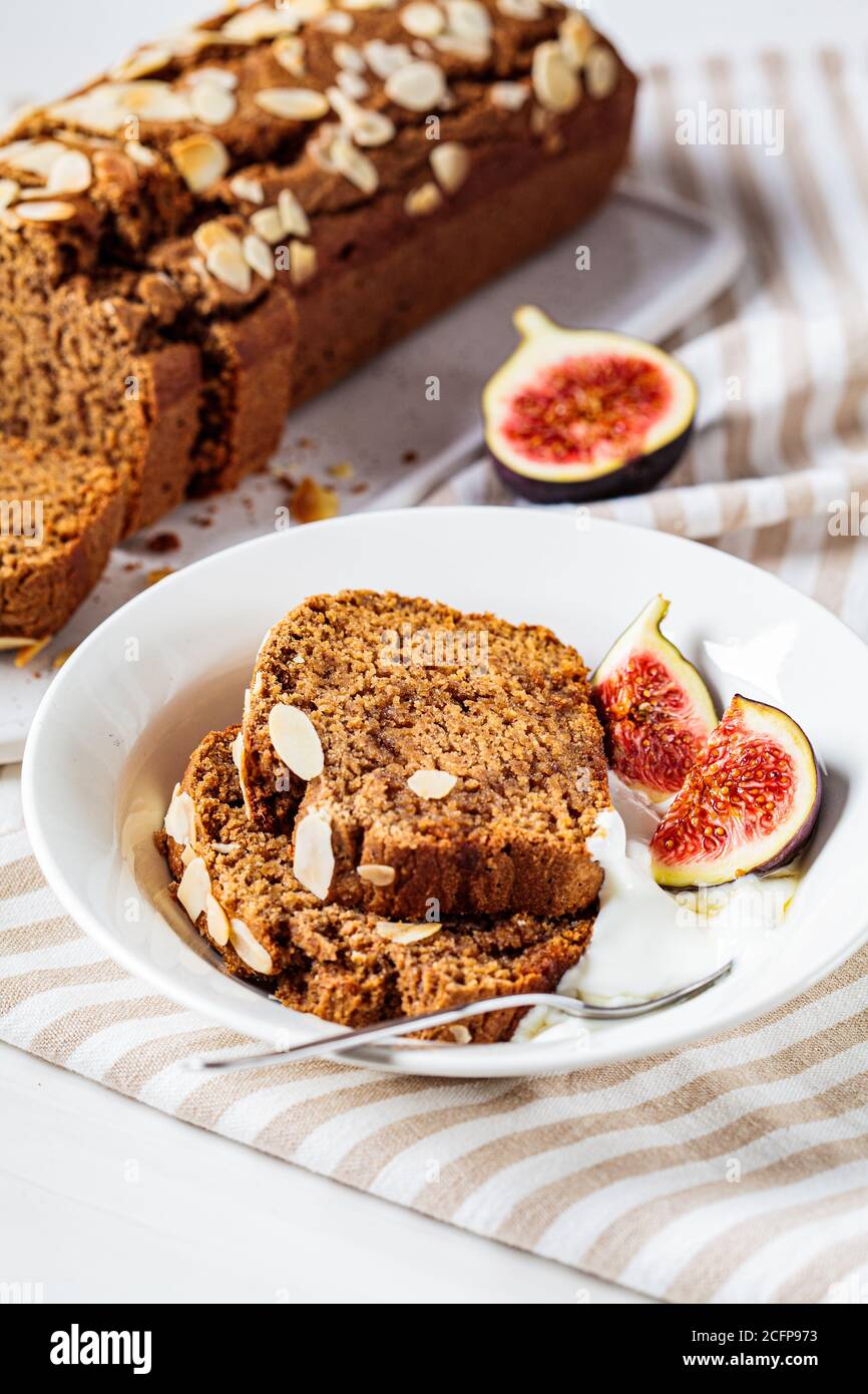 Portion of walnut-fruit cake with yogurt and figs. Stock Photo
