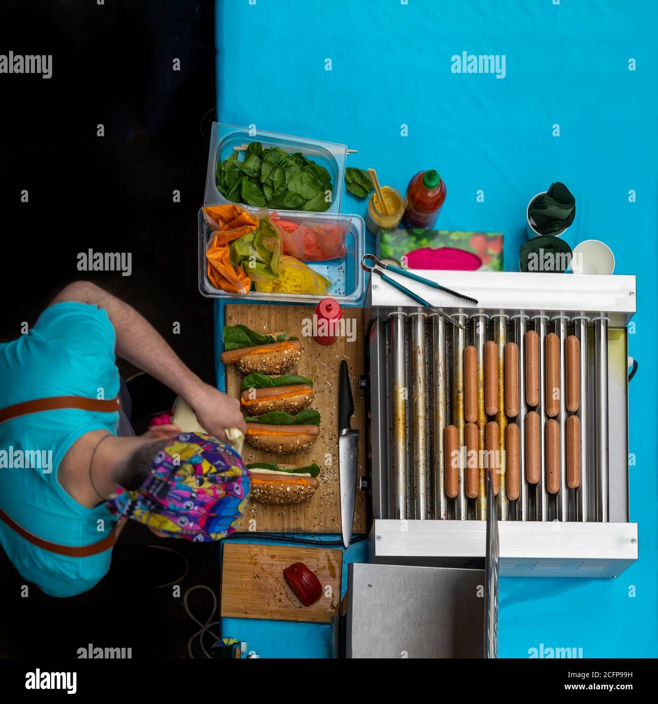 Cooking of vegan hotdogs. Top view. Street cook serving with healthy food, sausages. Hotdogs made from soy protein wiener, vegetables. Summer bbq Stock Photo