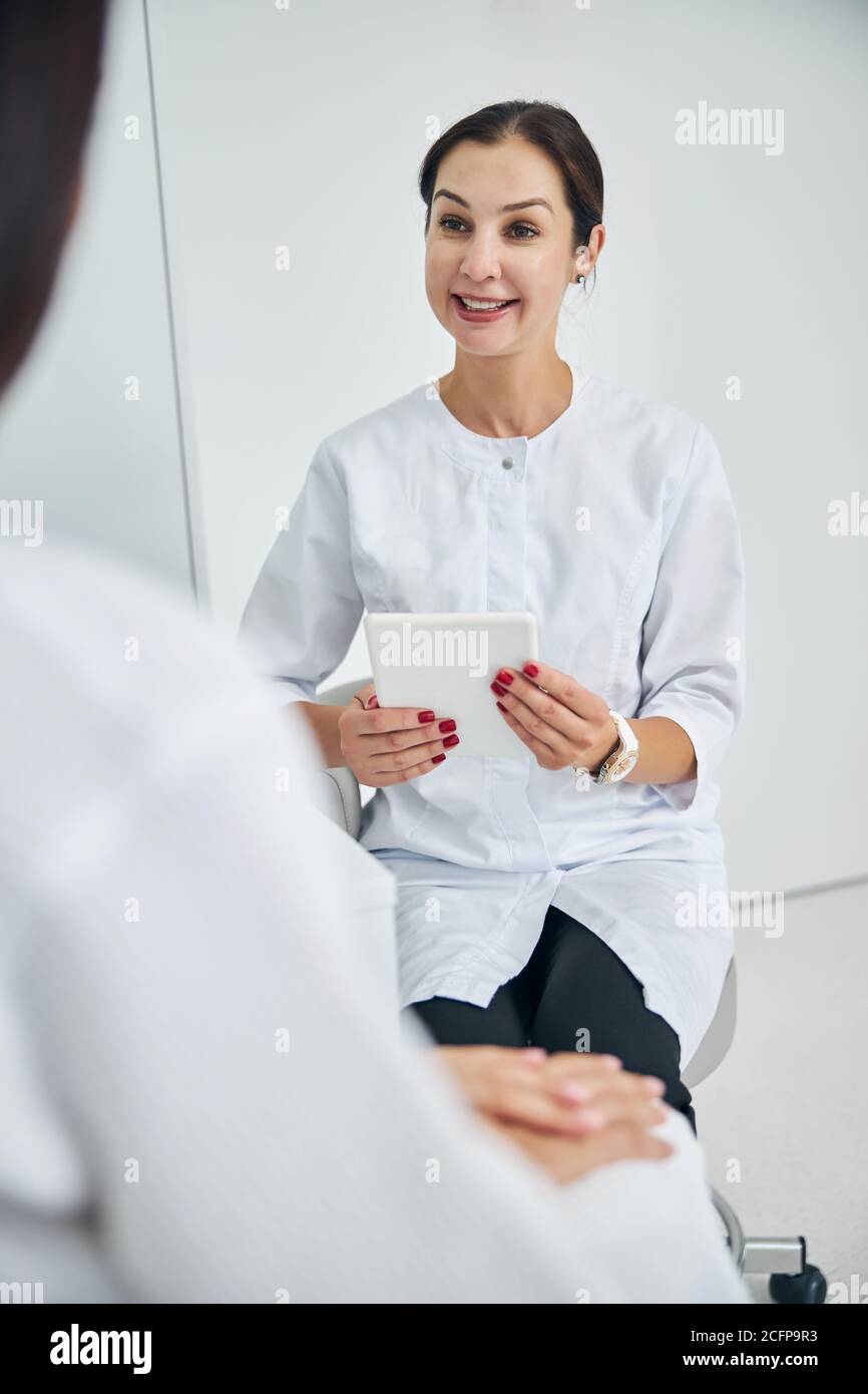Smiling cosmetologist consulting her client in a beauty parlor Stock Photo