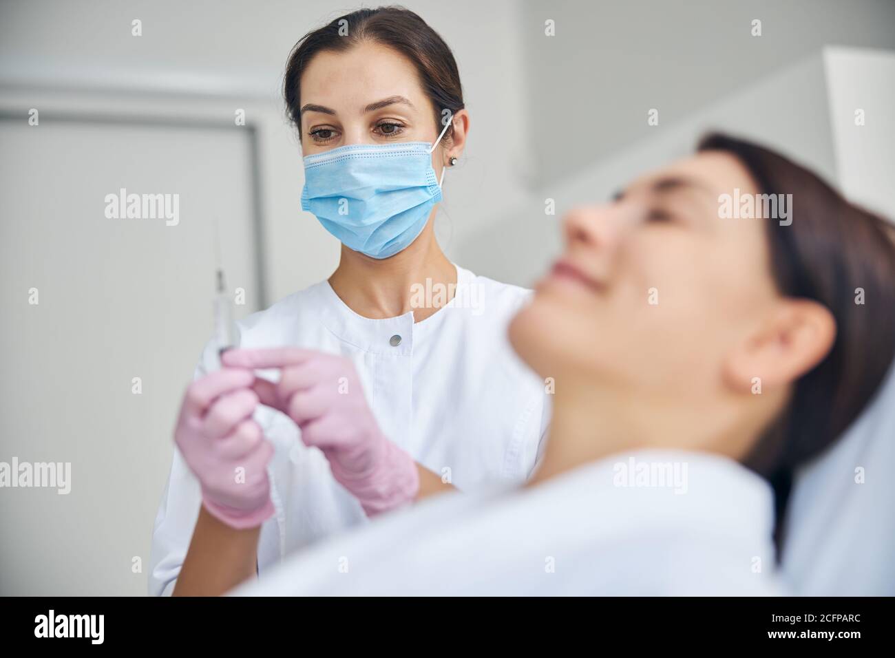 Dermatologist checking for air bubbles in the syringe Stock Photo