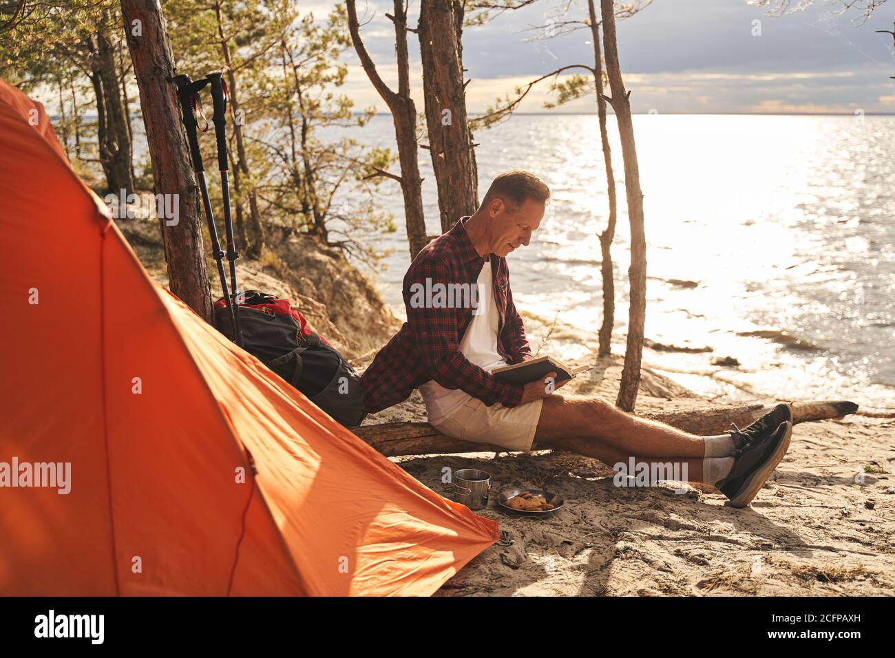 Sporty male resting with tent in nature Stock Photo