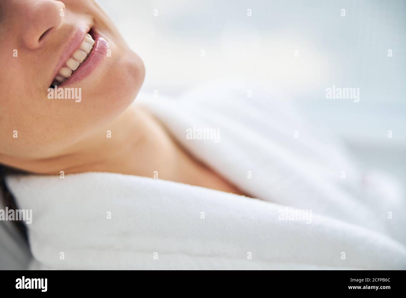 Merry female patient in a terry bathrobe Stock Photo