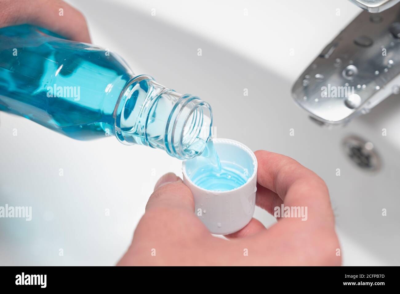 Hand of man Pouring Bottle Of Mouthwash Into Cap Stock Photo Alamy