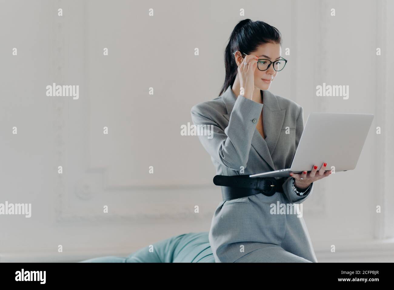 Elegant professional woman banker concentrated at screen of laptop ...