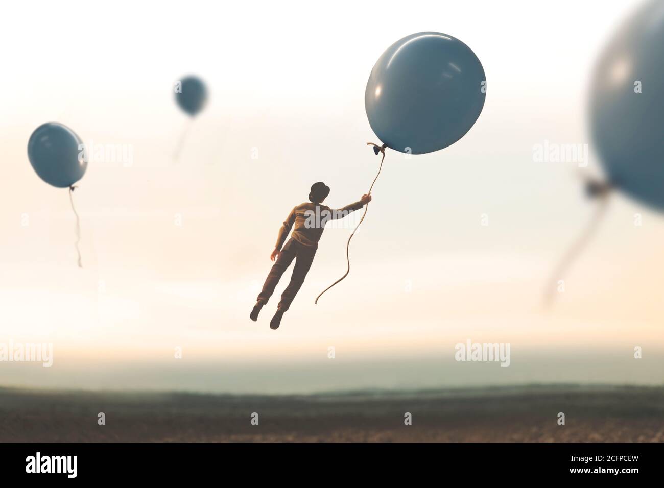 surreal moment, man flying away with a big balloon Stock Photo