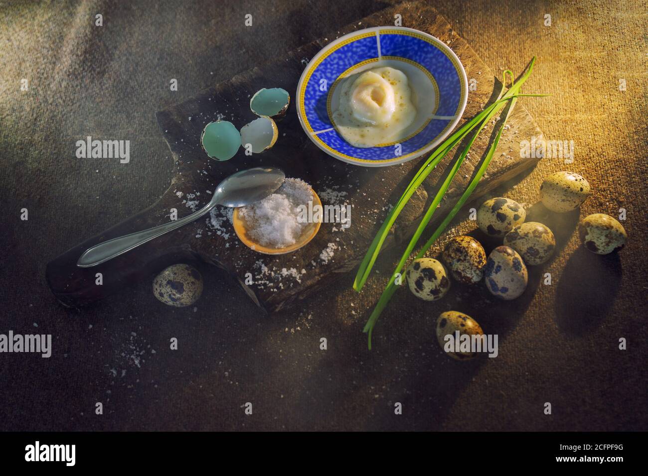 Closeup of quail eggs beside a wooden board with condiments for cooking Stock Photo