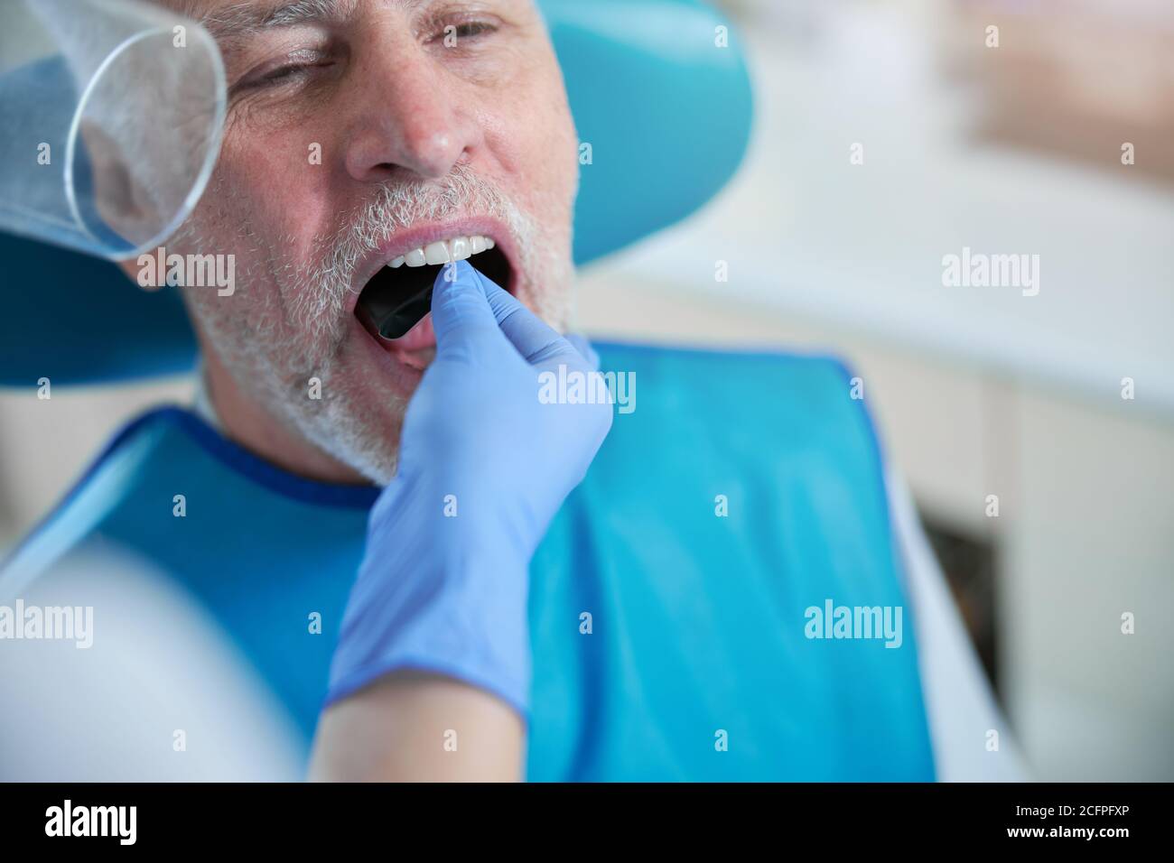 Dental specialist putting a film card inside a mouth of a patient Stock Photo Alamy