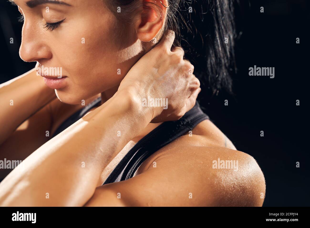 Young female athlete feeling neck muscle soreness Stock Photo