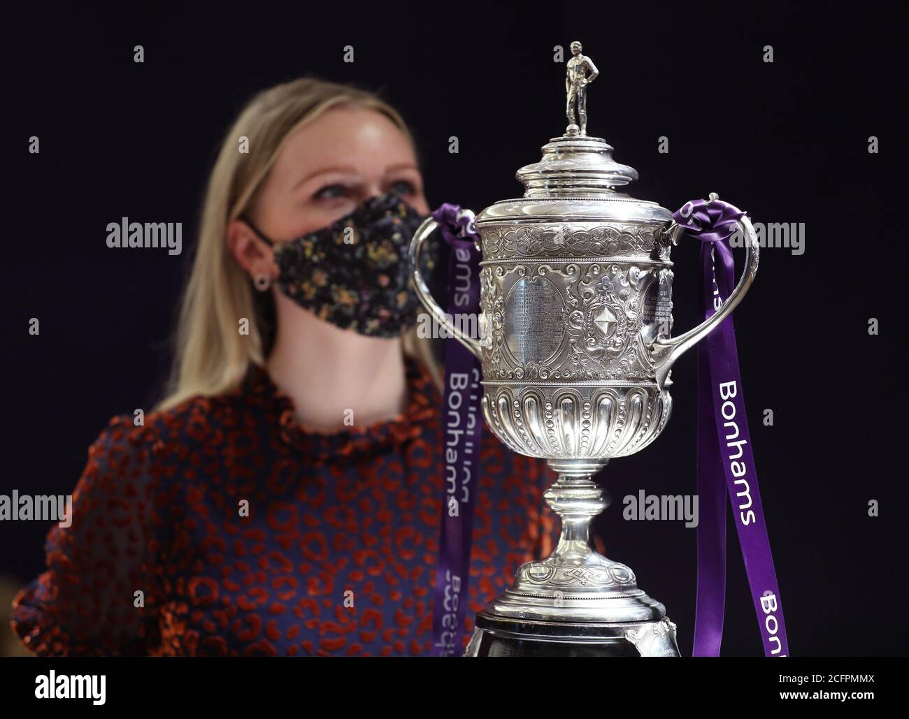 Laurel Kemp of Bonhams with the oldest surviving FA Cup trophy during a preview of the sporting Trophies Sale at which will take place as Bonhams New Bond Street saleroom on September 29. The silver two-handled cup, estimated at GBP 700,000 -900,000, was made by Vaughton and Sons of Birmingham in 1896, and was presented to the FA Cup winning teams between 1896 and 1910, including Manchester United, Manchester City, Everton, Newcastle United and Tottenham Hotspur. Stock Photo