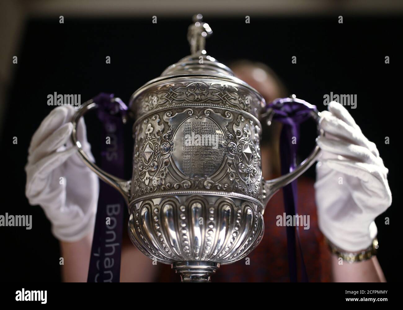 Laurel Kemp of Bonhams with the oldest surviving FA Cup trophy during a preview of the sporting Trophies Sale at which will take place as Bonhams New Bond Street saleroom on September 29. The silver two-handled cup, estimated at GBP 700,000 -900,000, was made by Vaughton and Sons of Birmingham in 1896, and was presented to the FA Cup winning teams between 1896 and 1910, including Manchester United, Manchester City, Everton, Newcastle United and Tottenham Hotspur. Stock Photo