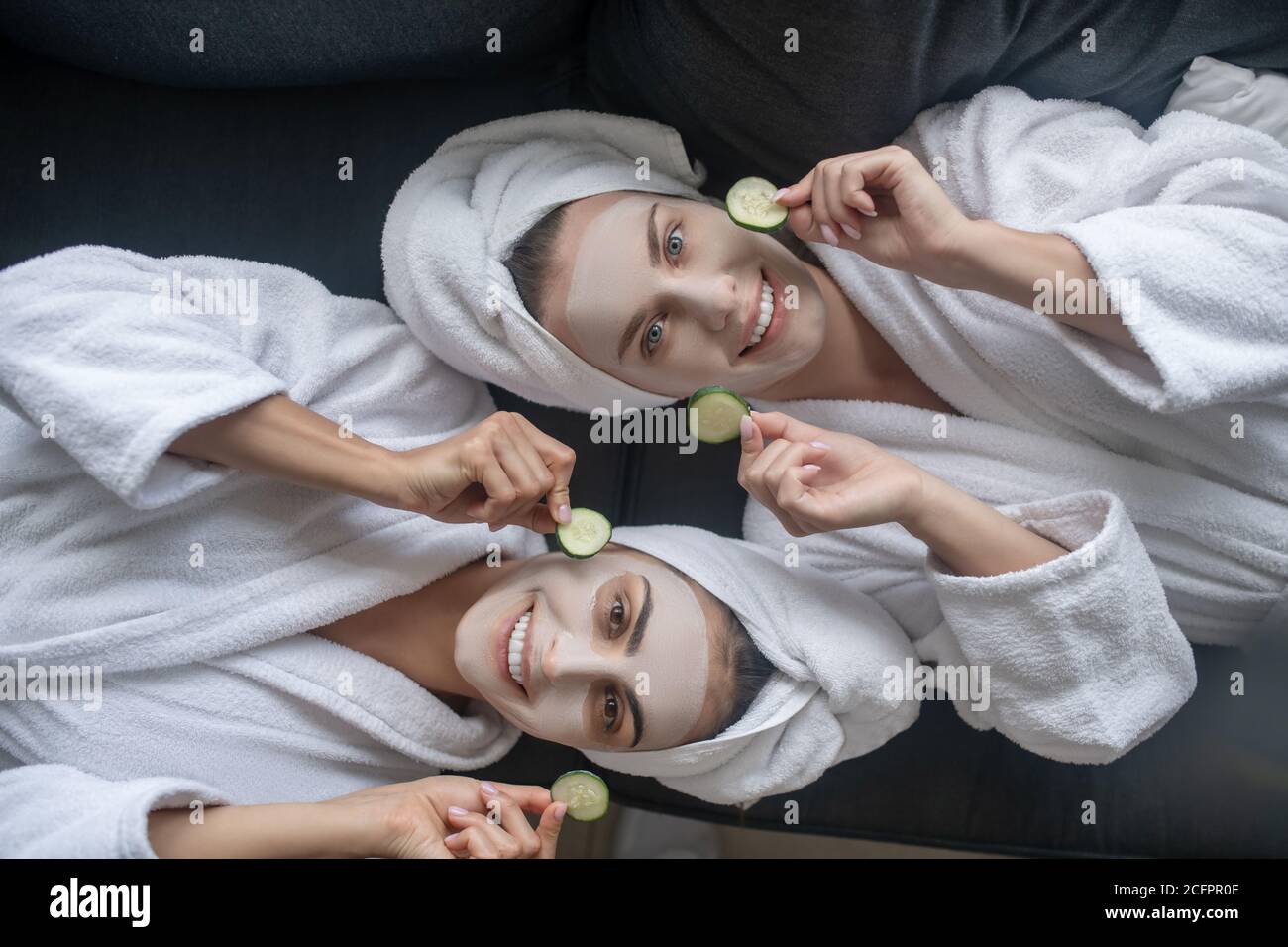 Young women holding slices of cucumber for face care Stock Photo