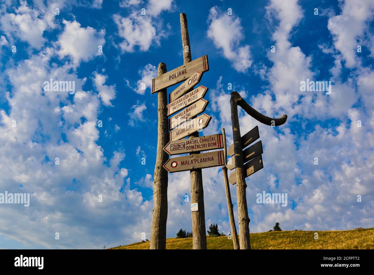 Wooden Signpost to Velika Planina in Slovenia. Beautiful Wooden Sign of Directions in Big Pasture Plateau. Stock Photo