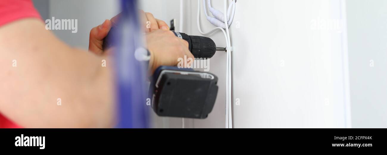 Master with punch in his hand makes holes. Stock Photo
