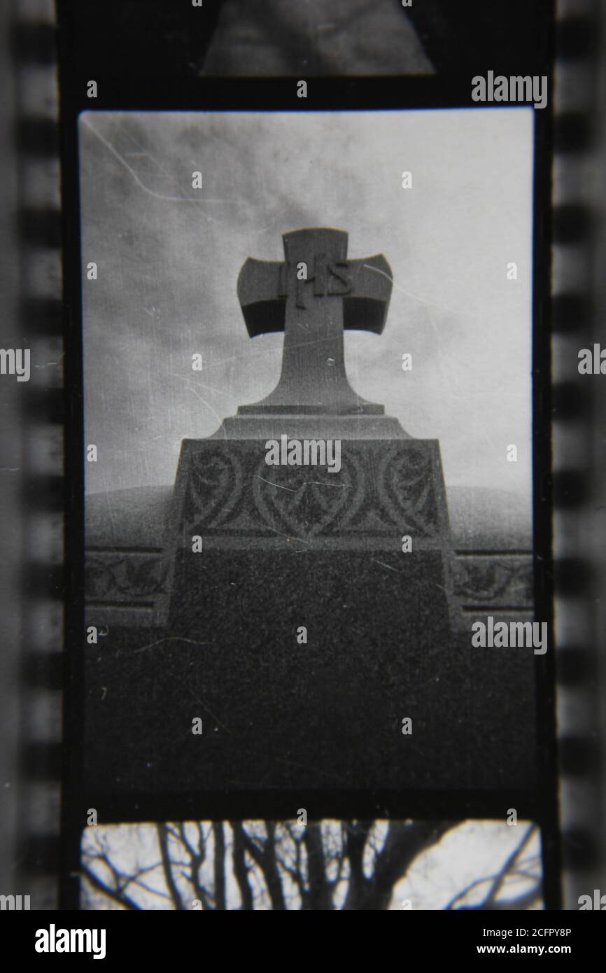 Fine 1970s vintage black and white photography of a Christian cross standing on top of a grave. Stock Photo
