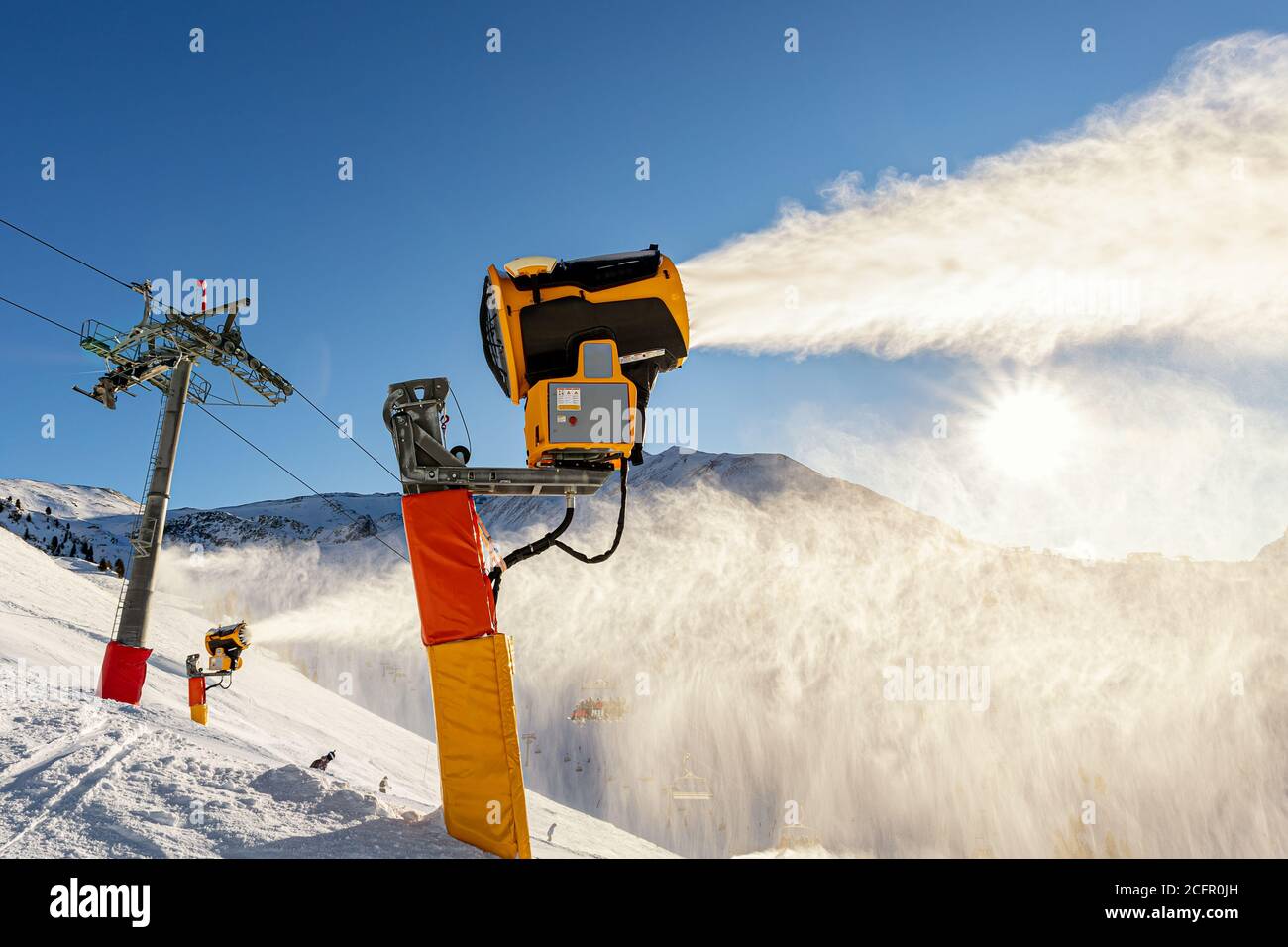 Operating artificial snow cannon near piste making snowy powder.Ski