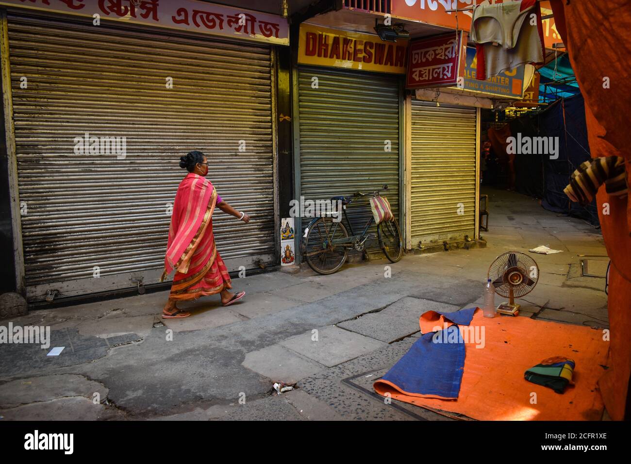 Kolkata, India. 07th Sep, 2020. A woman is walking between a closed market during the Bi- weekly lockdown in the West Bengal state, amidst the spread of the COVID-19 disease in Kolkata. India displaced Brazil to take second place after the United States in terms of coronavirus infections, with 90,082 new cases. The total number of coronavirus cases mounted to 42, 04,613, while the death toll climbed to 71,642 with 1,016 fatalities being reported in a span of 24 hours. (Photo by Sudipta Das/Pacific Press) Credit: Pacific Press Media Production Corp./Alamy Live News Stock Photo