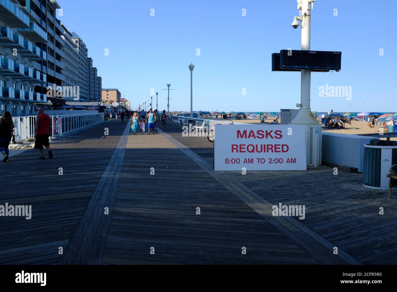 Ocean City Maryland Boardwalk on Labor Day Weekend with Masks Required Sign.  People behind the sign are maskless Stock Photo