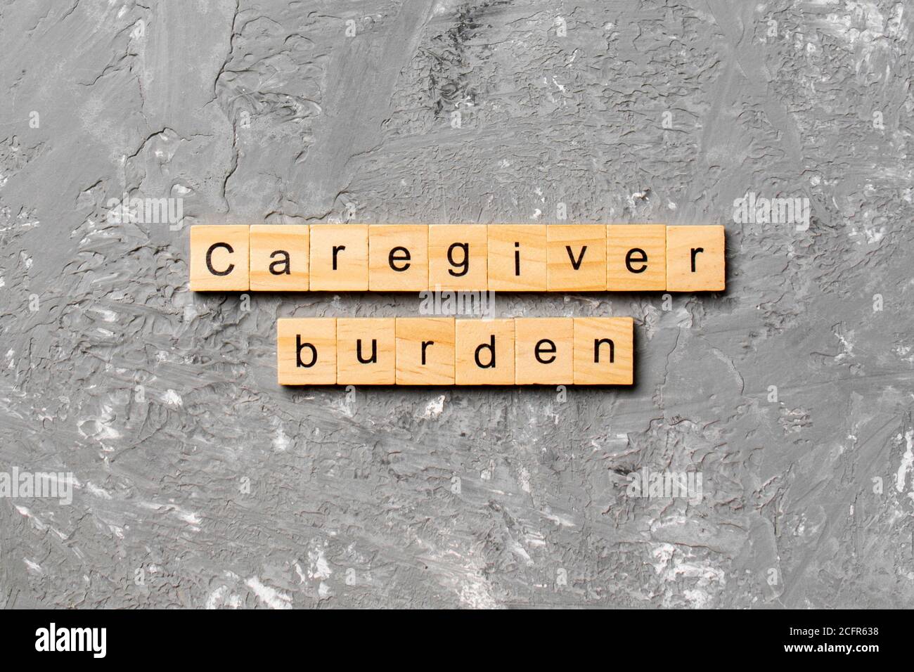 Caregiver burden word written on wood block. Caregiver burden text on