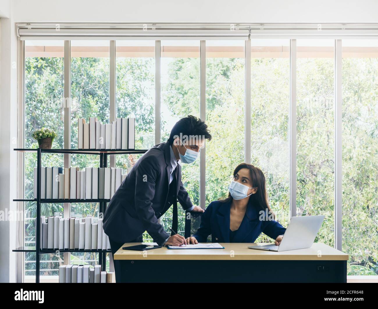 Asian business man and woman wearing suit and protective face masks ...