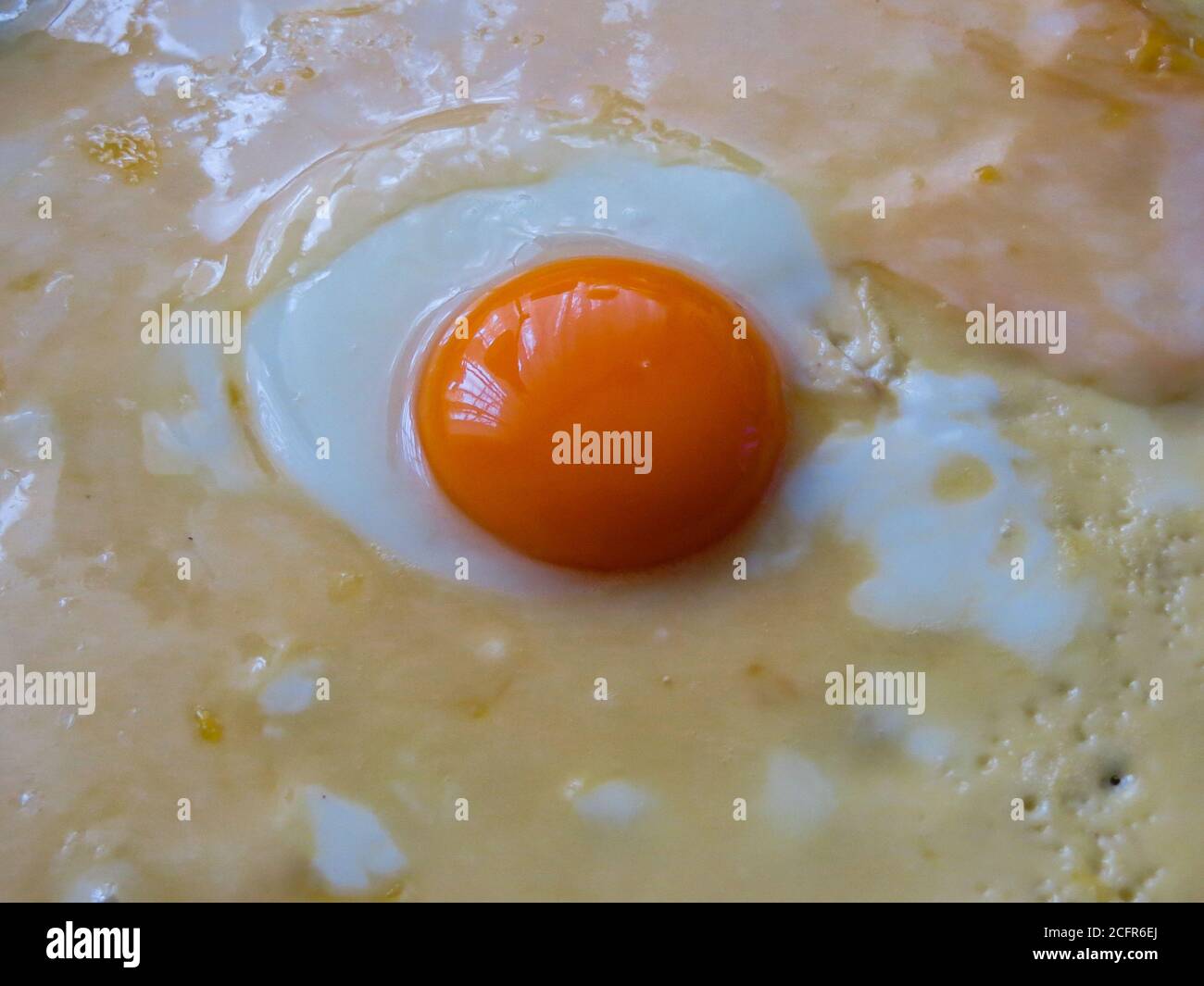 bright orange chicken yolk in the center of the pan Stock Photo Alamy