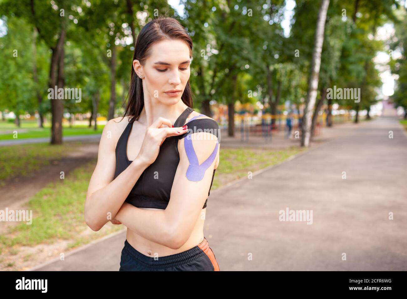 Young stunning muscular woman wearing black sports outfit. Fit