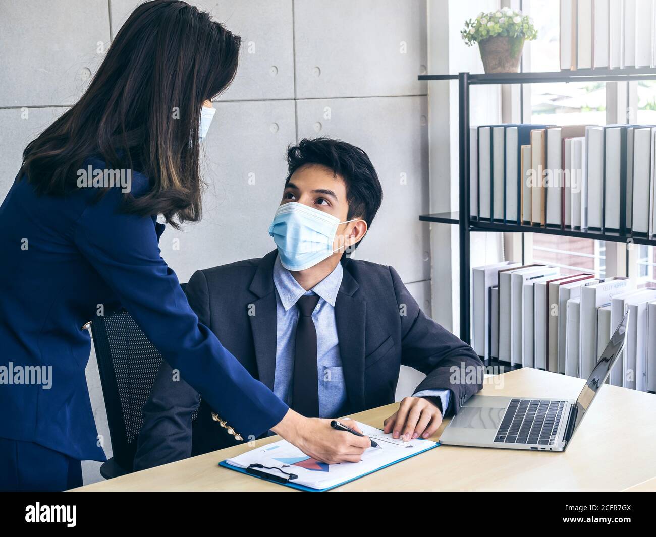 Asian business man and woman wearing suit and protective face masks ...