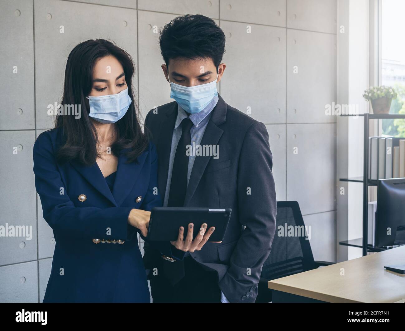 Asian business man and woman wearing suit and protective face masks ...