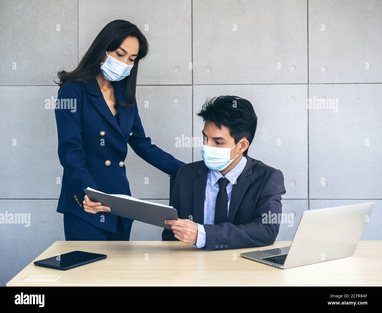 Asian business man and woman wearing suit and protective face masks ...