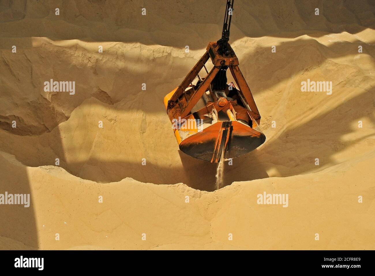 Grab bucket digging sand in a sand pit Stock Photo