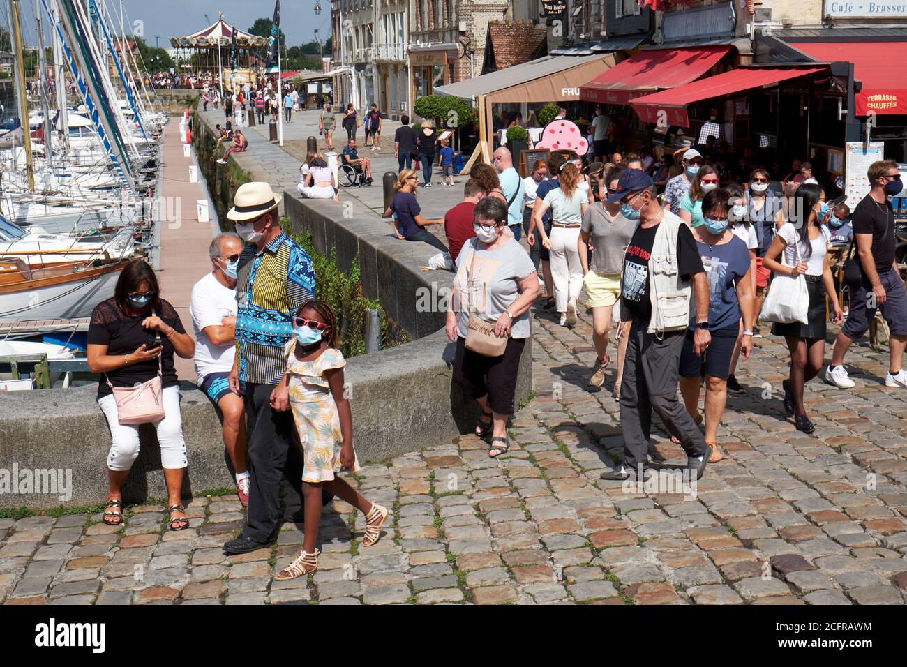 Holidaymakers and tourists wearing face masks during the COVID-19 pandemic in the picturesque harbour town of Honfleur in Normandy Stock Photo