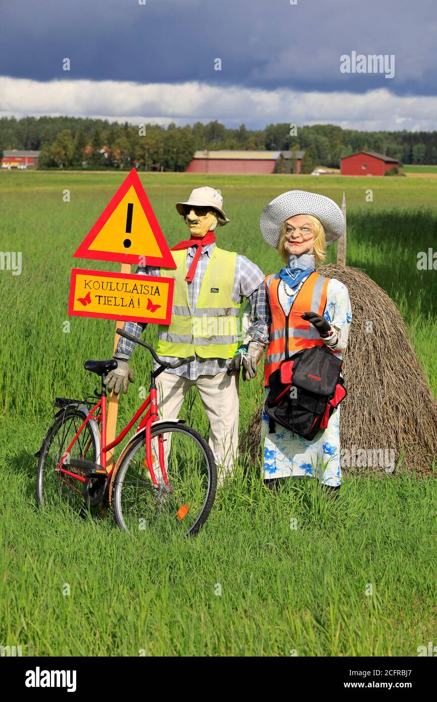 Funny arrangement of an couple with safety vests on alerts motorists of the Hiiden koulu school ahead. Pertteli, Salo, Finland.  September 6, 2020. Stock Photo