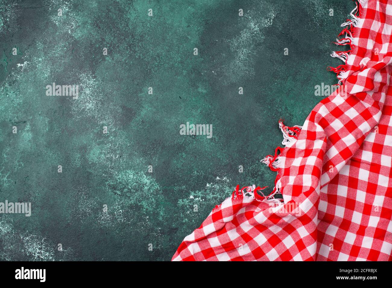 Red checkered tablecloth on green background Stock Photo