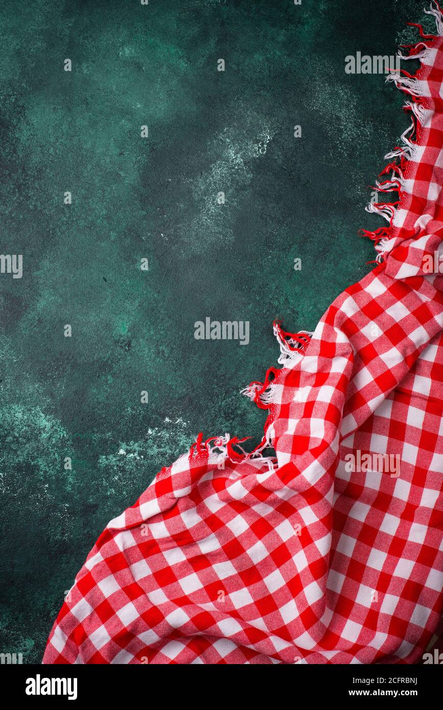 Red checkered tablecloth on green background Stock Photo