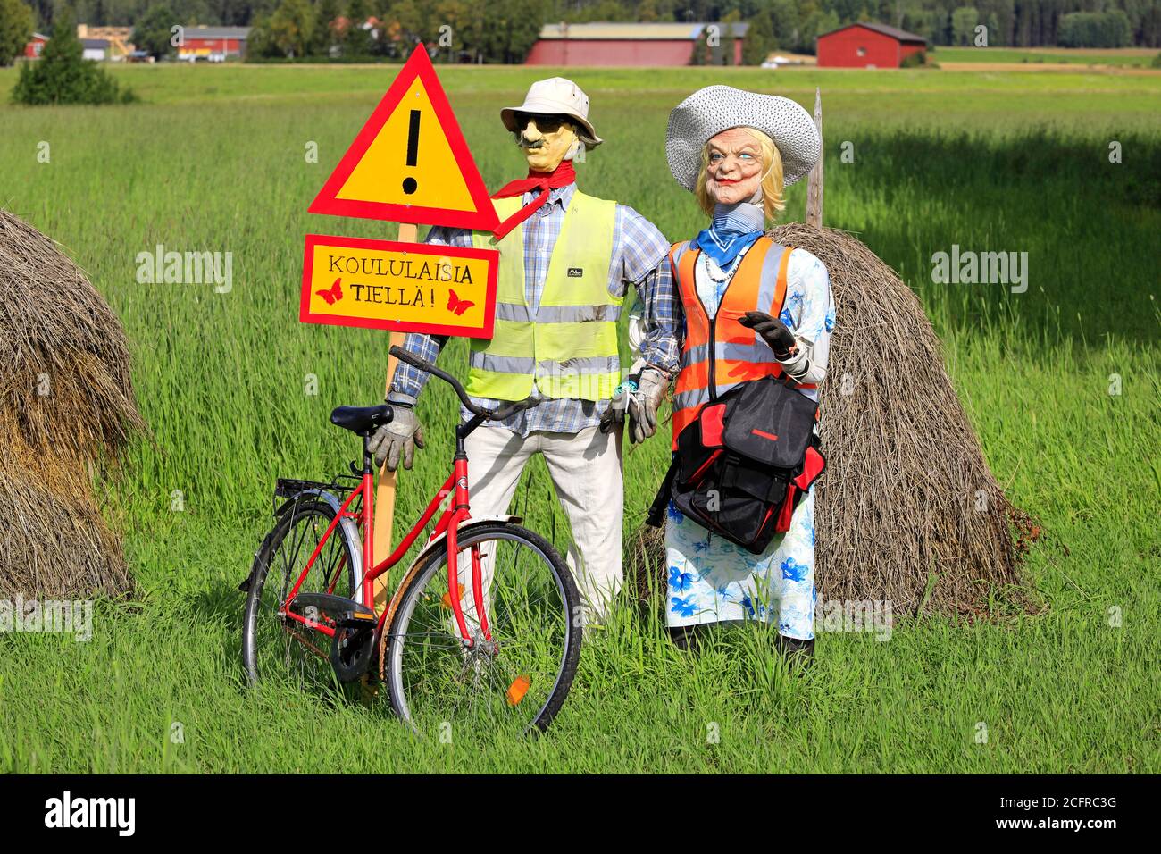 Funny arrangement of an couple with safety vests on alerts motorists of the Hiiden koulu school ahead. Pertteli, Salo, Finland.  September 6, 2020. Stock Photo