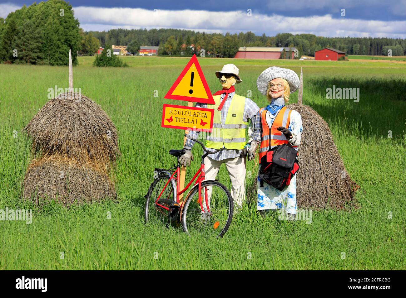 Funny arrangement of an couple with safety vests on alerts motorists of the Hiiden koulu school ahead. Pertteli, Salo, Finland. September 6, 2020. Stock Photo