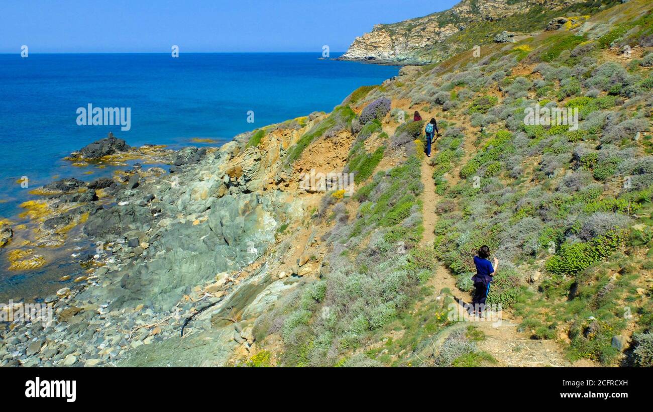 Corsica. Cap Corse peninsula. Family of tourists on a hike along a coastal path Stock Photo