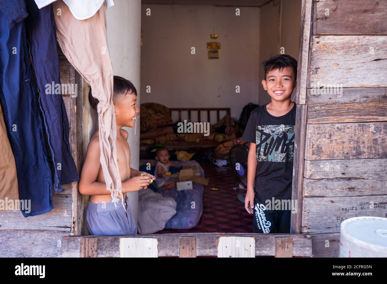 Kota Kinabalu / Malaysia January 13, 2019 three brothers looking at the camera at the door of