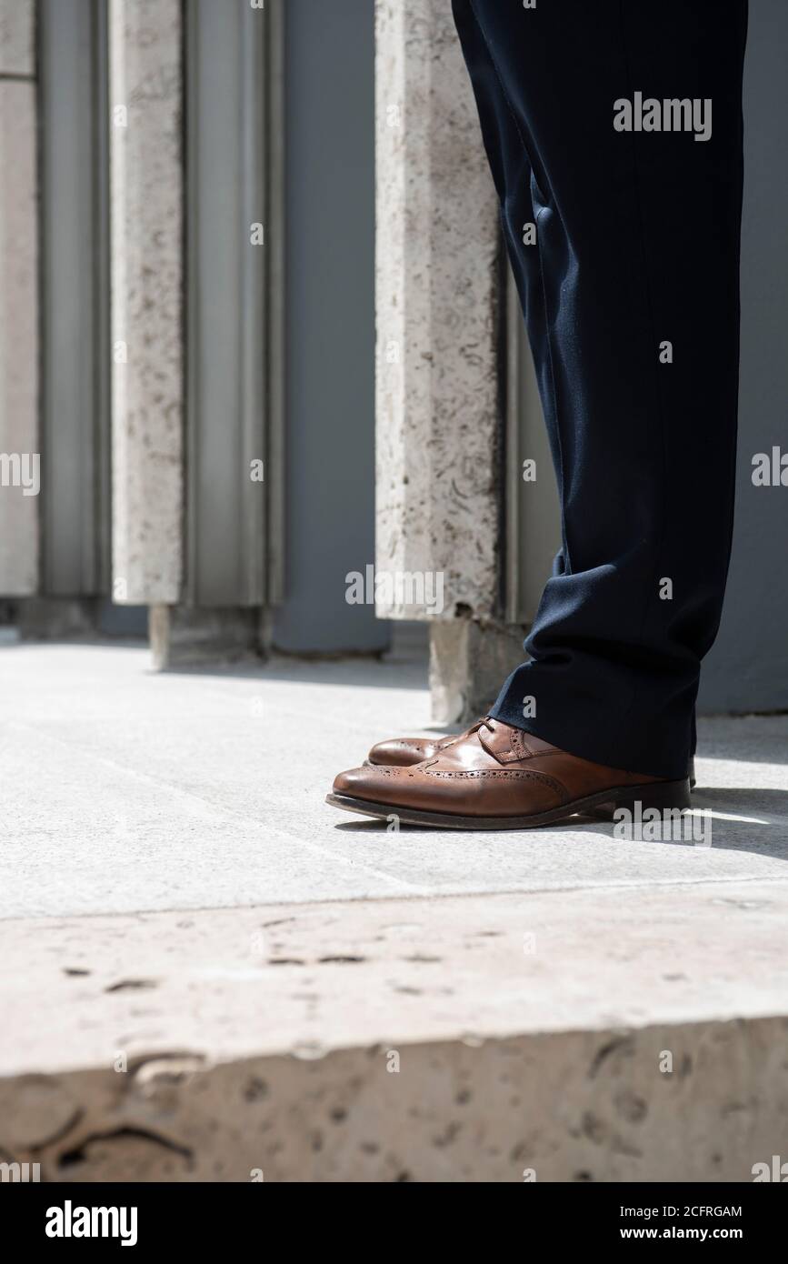 Figure wearing brown brogues on the steps of the plaza. The Economist Building, London, United Kingdom. Architect: Alison & Peter Smithson, dsdha refu Stock Photo