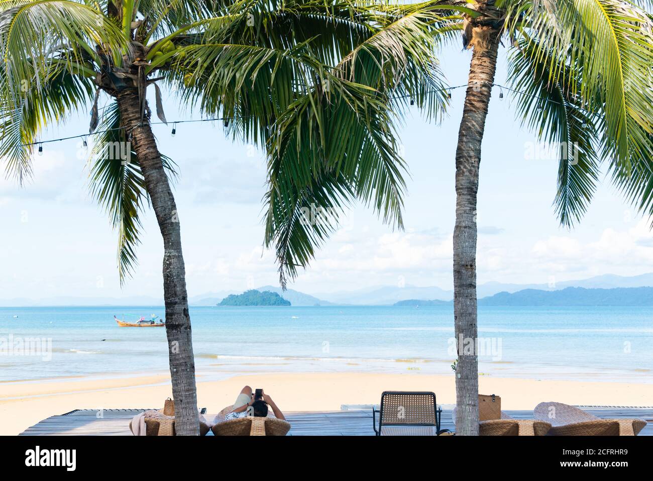 Man relaxing laying down on beach, ocean view Stock Photo